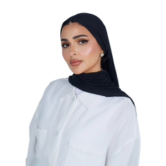Woman wearing a black hijab and white shirt on a white background