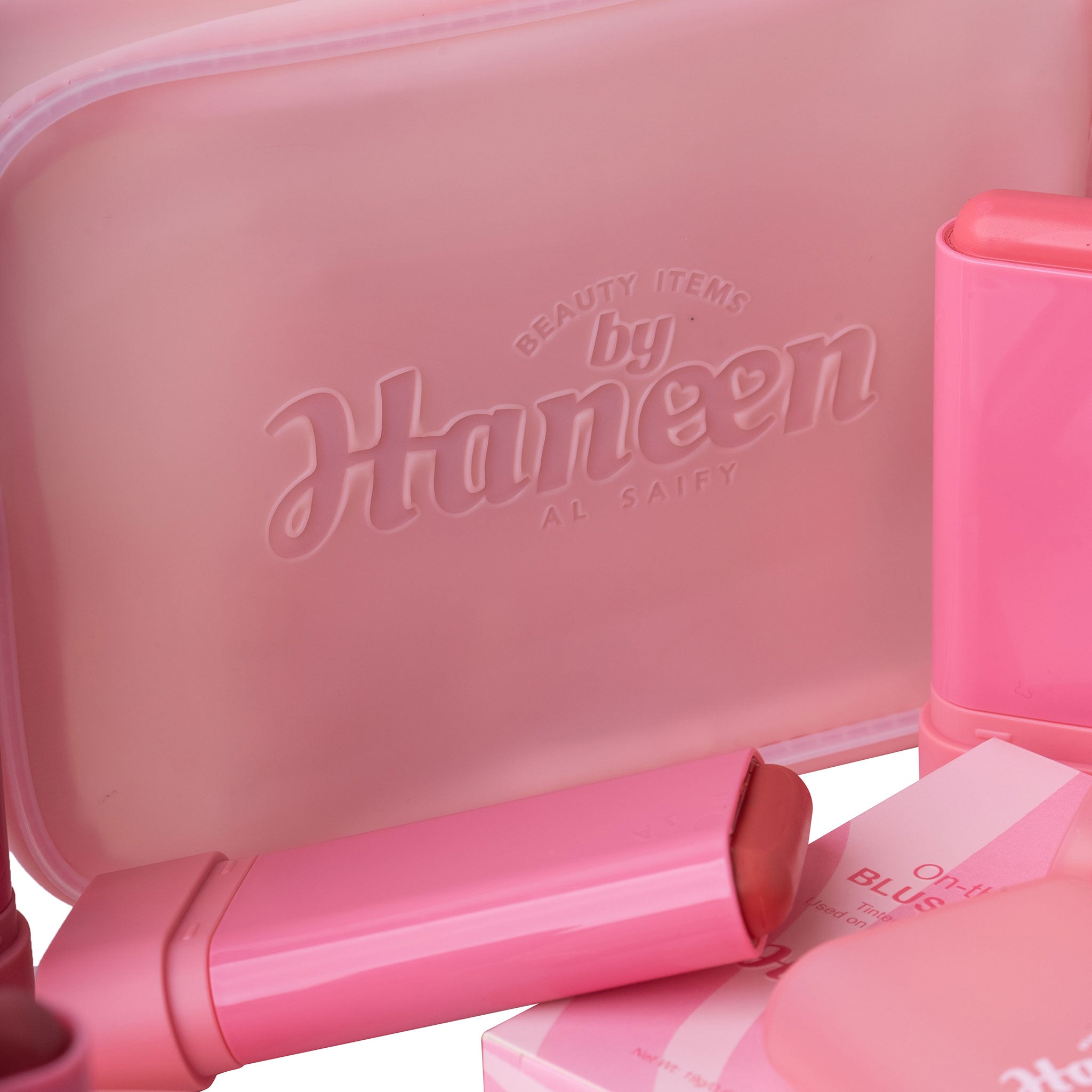 Pink cosmetic set with 'Haneen' branding on a white background
