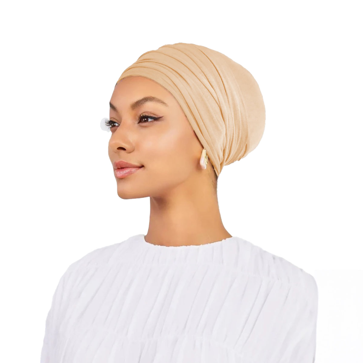 Woman wearing a beige headscarf on a white background