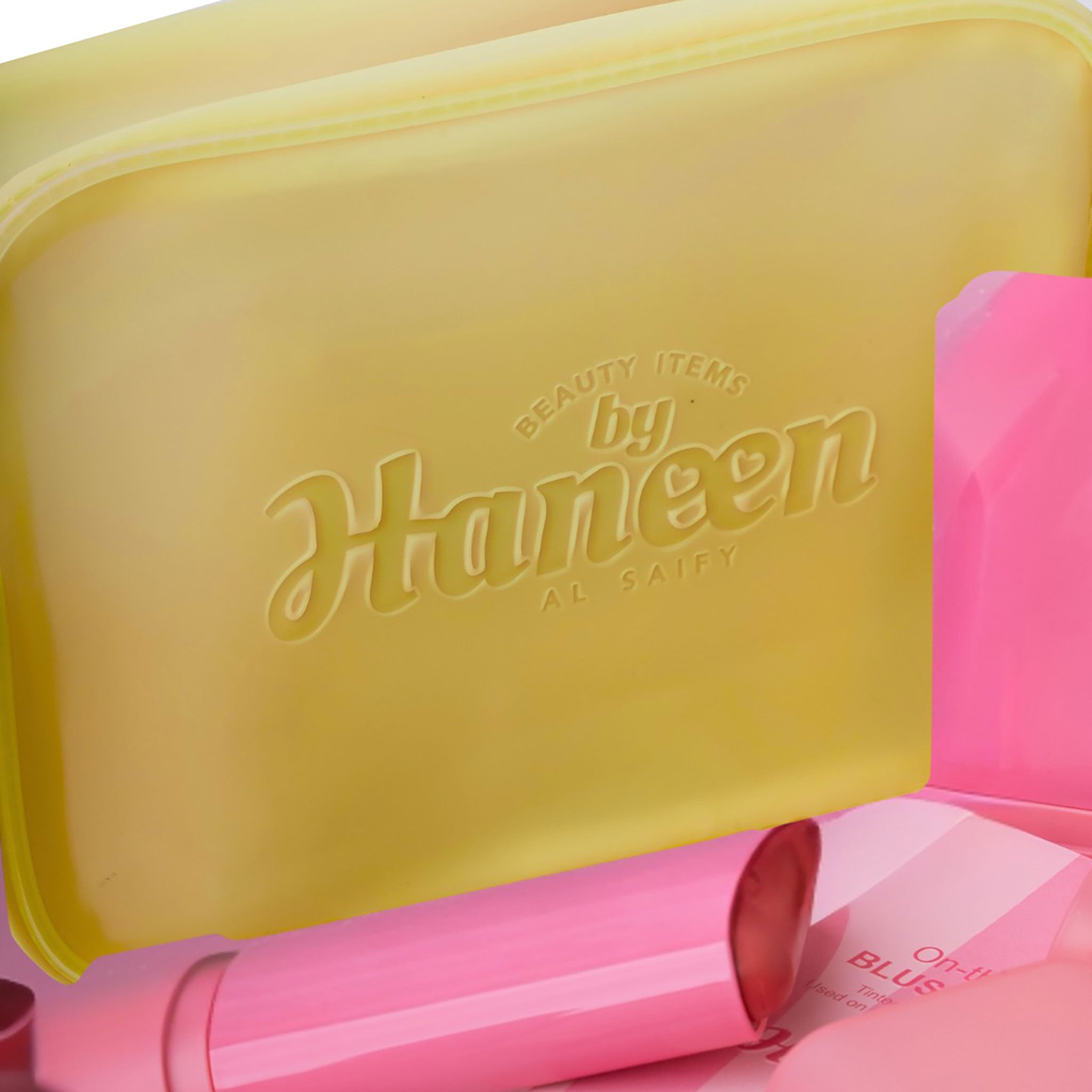 Yellow case with 'Beauty Items by Haneen' branding, containing pink items.