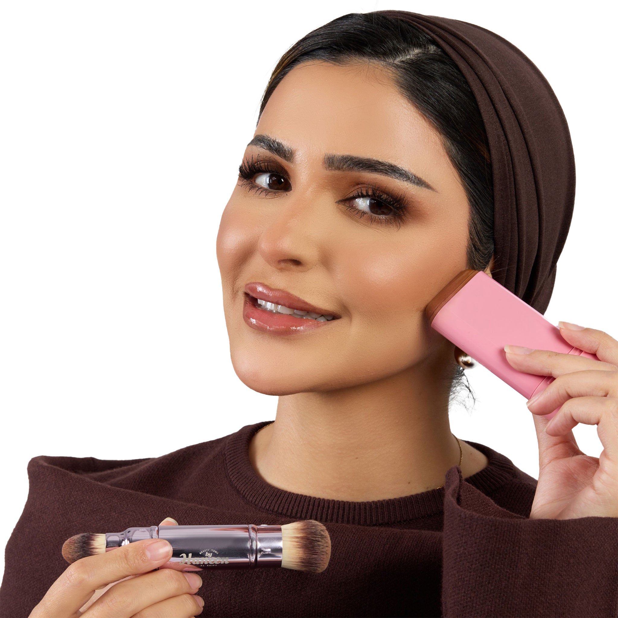 Woman applying makeup with a pink brush and clear container on a white background