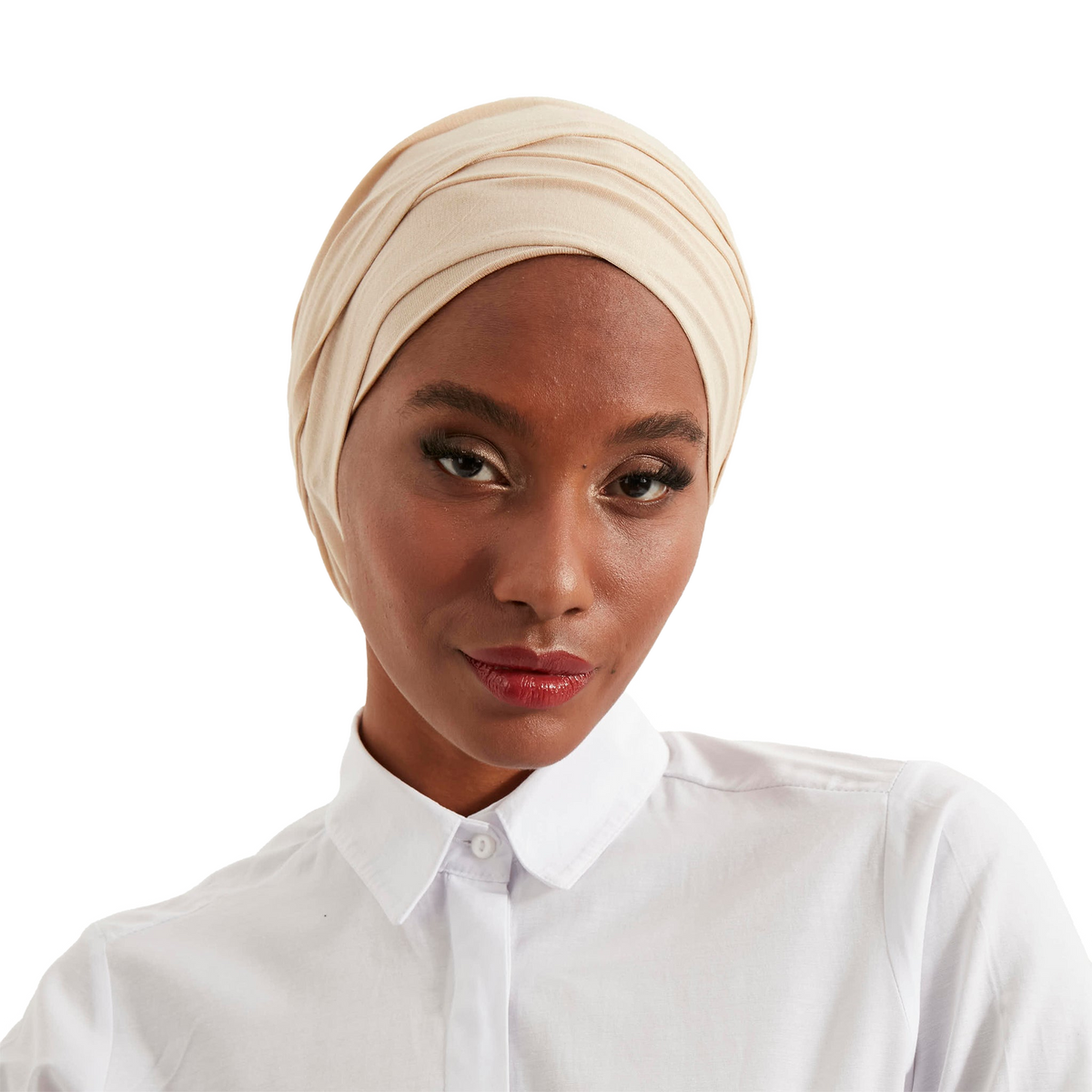 Woman wearing a beige headscarf and white shirt on a white background