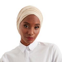Woman wearing a beige headscarf and white shirt on a white background