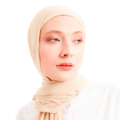 Woman wearing a beige hijab against a white background