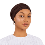 Woman wearing a brown headscarf on a white background