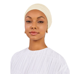 Woman wearing a beige headscarf and white top on a white background