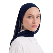 Woman wearing a navy hijab and white shirt on a white background
