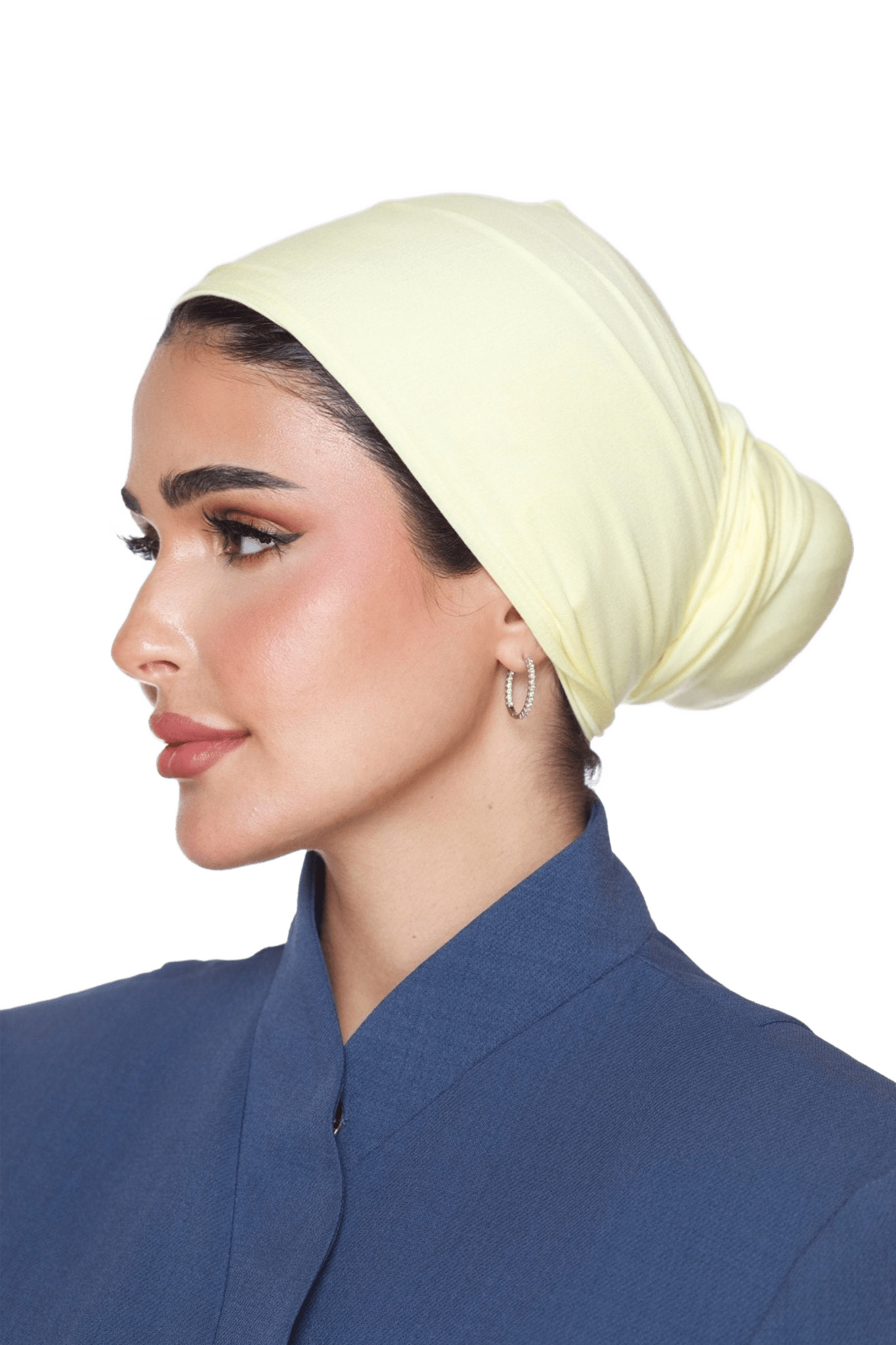 Woman wearing a light yellow headscarf and blue outfit on a white background