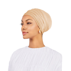 Woman wearing a beige headscarf on a white background