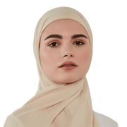 Woman wearing a beige hijab against a white background