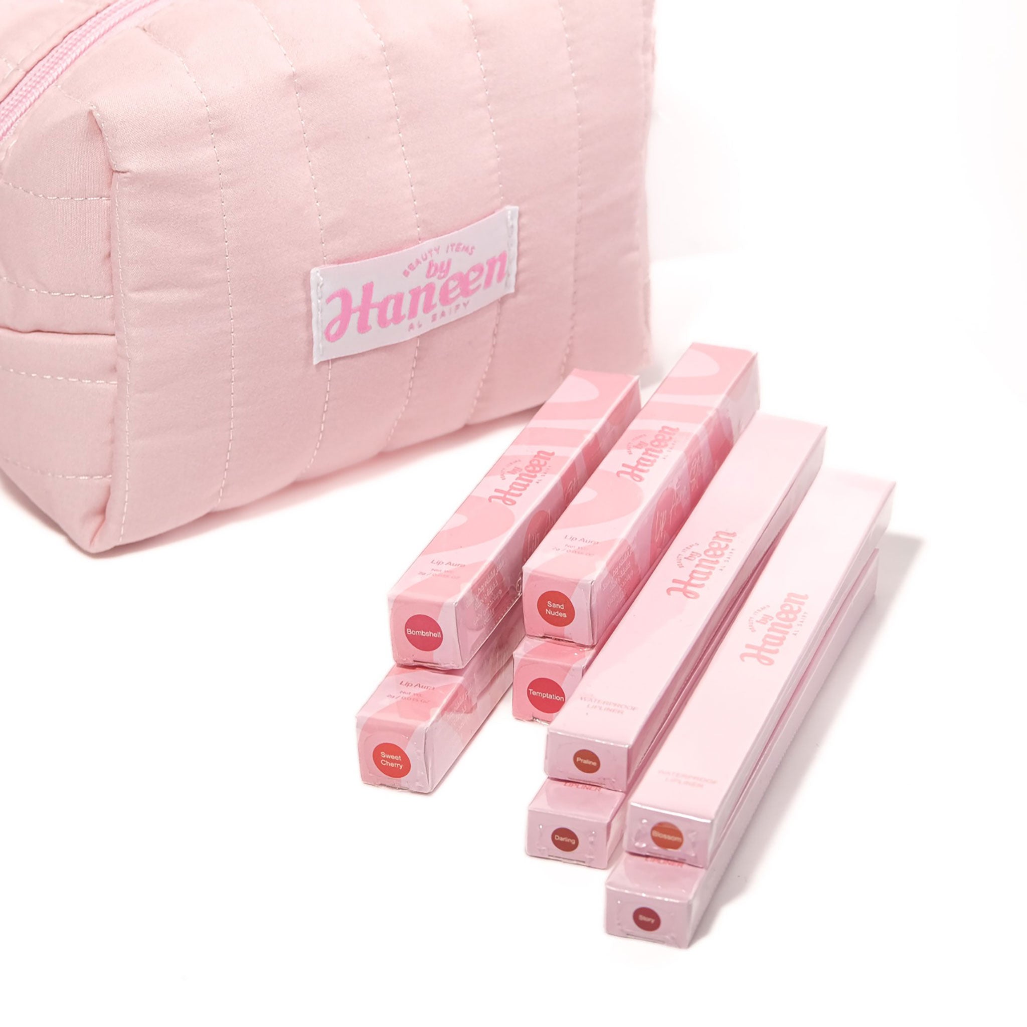 Pink makeup case with 'Haneen' branding and pink lip gloss sticks on a white background