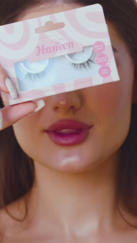 Woman holding a package of false eyelashes with a white background